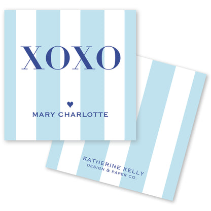 a light blue and white striped card with the word "XOXO" prominently displayed in the center. Below the word "XOXO", the name "Mary Charlotte" is written, and at the bottom, the text "KATHERINE KELLY DESIGN & PAPER CO." is visible.