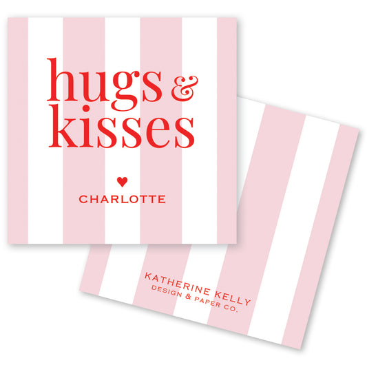 a pink and white striped card with the text "hugs & kisses" and " Charlotte" printed on it.