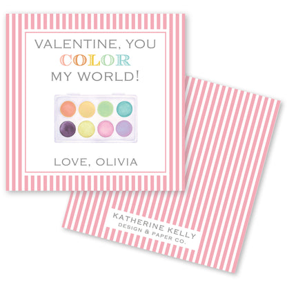 The image is a Valentine's Day card with a pink and white striped background. The card features a colorful paint palette and a message that reads "Valentine, you color my world!" The card also includes a name and a logo for "Katherine Kelly Design & Paper Co."