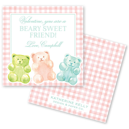 The image is a Valentine's Day card featuring three teddy bears in different colors - green, pink, and blue - sitting together on a pink and white checkered background.