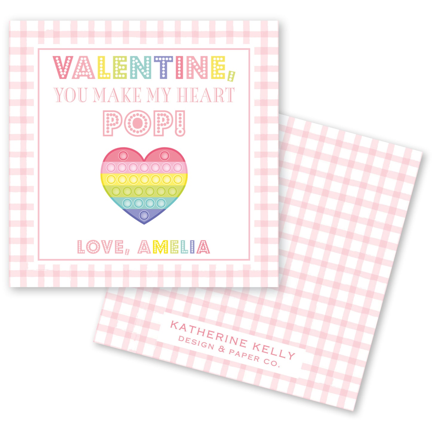 The image is a Valentine's Day card with a pink and white checkered background. The card features a heart-shaped pop-up design and text that reads "Valentine! You make my heart pop!" The card also includes the name "Love, Amelia" and the logo of "Katherine Kelly Design & Paper Co."