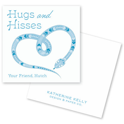 The image is a square card with a blue snake design and the text "Hugs and Hisses" written on it.