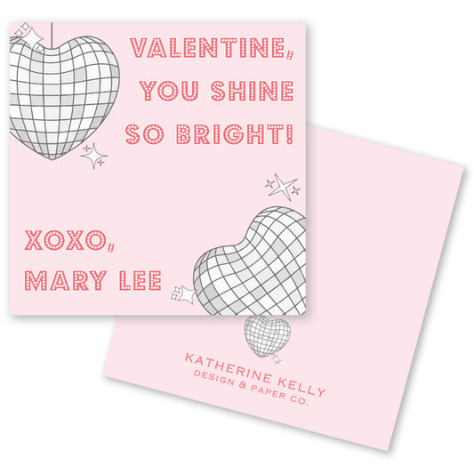 The image is a Valentine's Day card with a pink background and a heart-shaped design. The card features a message that reads "Valentine, you shine so bright! XOXO, Mary Lee" along with a small heart-shaped design. The card also includes the text "KATHERINE KELLY DESIGN & PAPER CO."