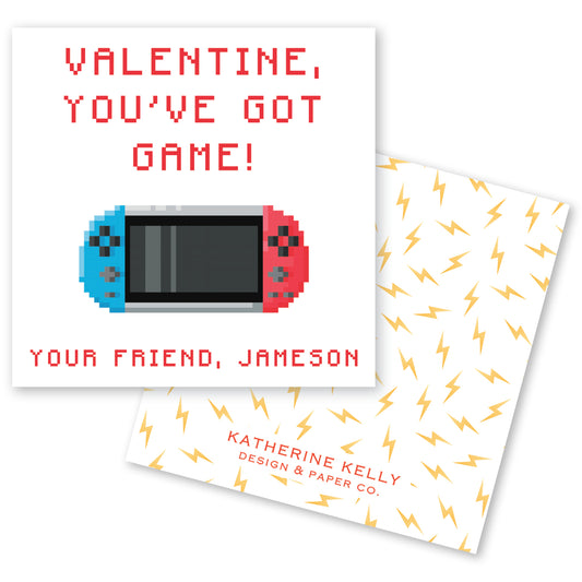 The image is a Valentine's Day card featuring a pixelated game controller and the text "Valentine, you've got game!" along with the names "Your Friend, Jameson" and "Katherine Kelly Design & Paper Co."