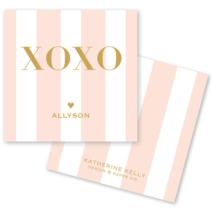 a pink and white striped card with the word "XOXO" written on it.