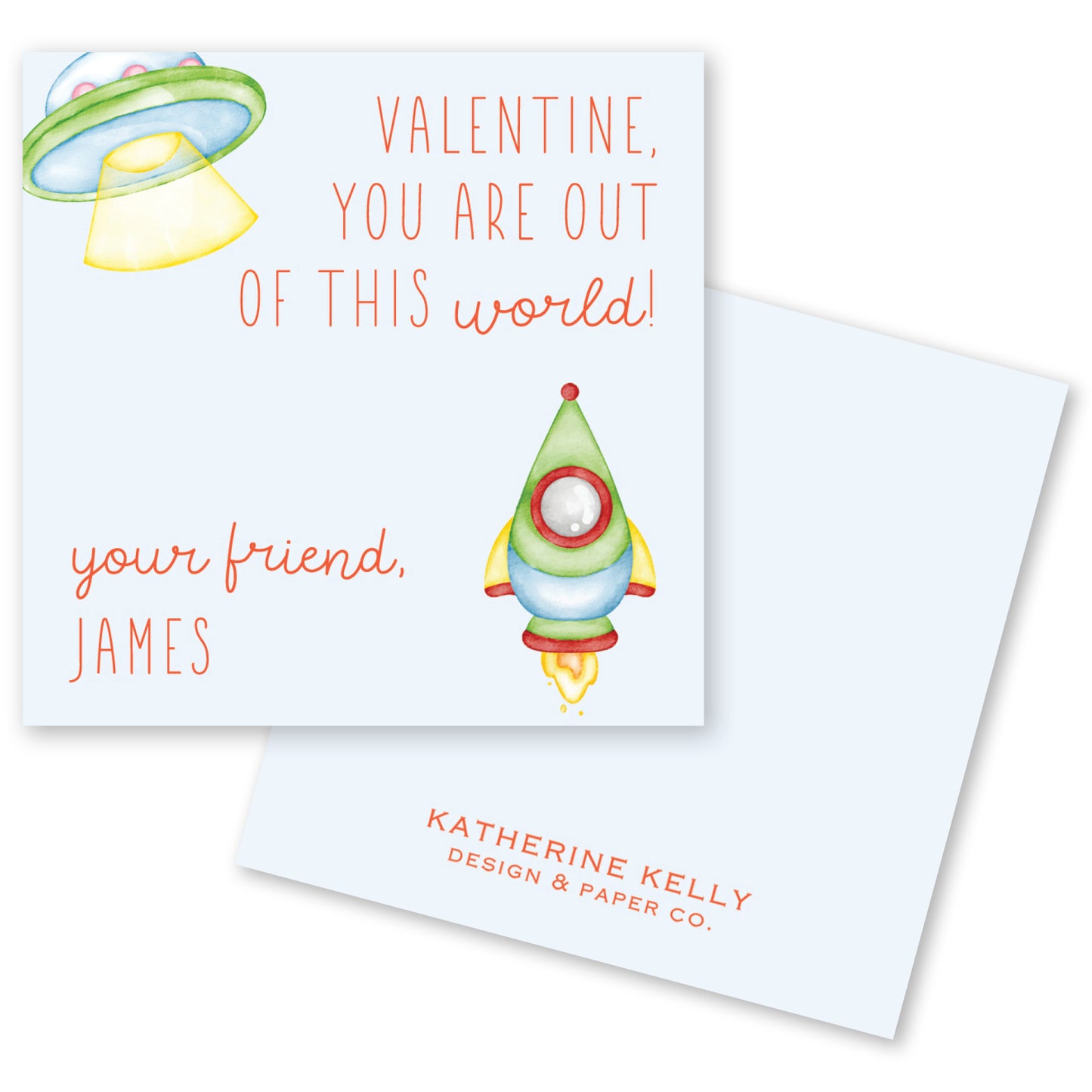 The image is a Valentine's Day card with a space theme, featuring a rocket ship and an alien. The card has a message that reads "Valentine, you are out of this world!" and includes the name "James" below the rocket ship. The card also has a logo for "Katherine Kelly Design & Paper Co."