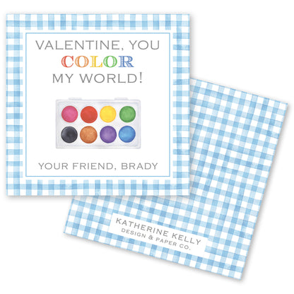 The image is a Valentine's Day card with a blue and white checkered border. The card features a watercolor palette and a message that reads "Valentine, you color my world!" The card also includes a message that says "Your friend, Brady" and a logo for "Katherine Kelly Design & Paper Co."