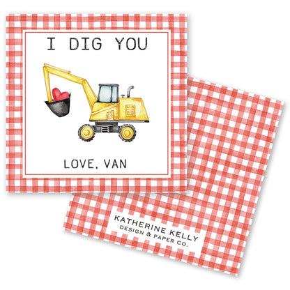 The image is a Valentine's Day card featuring a yellow construction vehicle with a heart in its bucket, accompanied by the text "I DIG YOU LOVE. VAN" and "KATHERINE KELLY DESIGN & PAPER CO."
